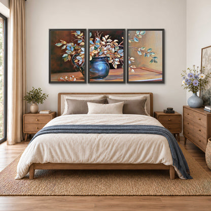 White and peach flowering branches arranged in a blue vase against a warm ochre background 3 piece framed canvas wall art styled in an interior