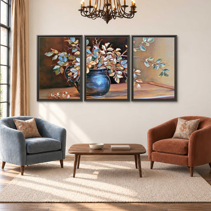 White and peach flowering branches arranged in a blue vase against a warm ochre background 3 piece framed canvas wall art styled in an interior