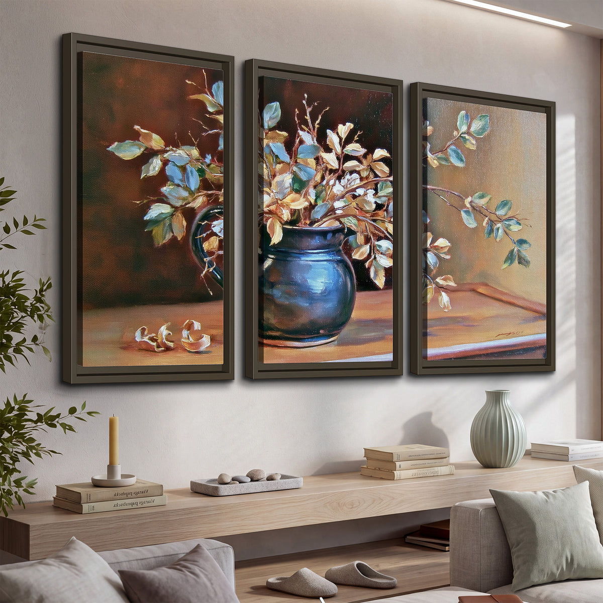 White and peach flowering branches arranged in a blue vase against a warm ochre background 3 piece framed canvas wall art displayed in a console