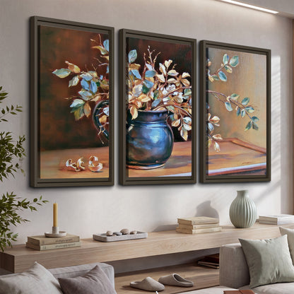 White and peach flowering branches arranged in a blue vase against a warm ochre background 3 piece framed canvas wall art displayed in a console
