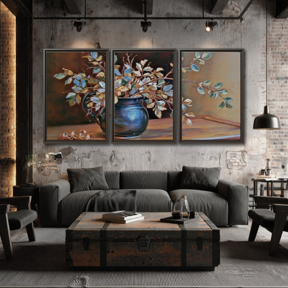 White and peach flowering branches arranged in a blue vase against a warm ochre background 3 piece framed canvas wall art displayed in a industrial room