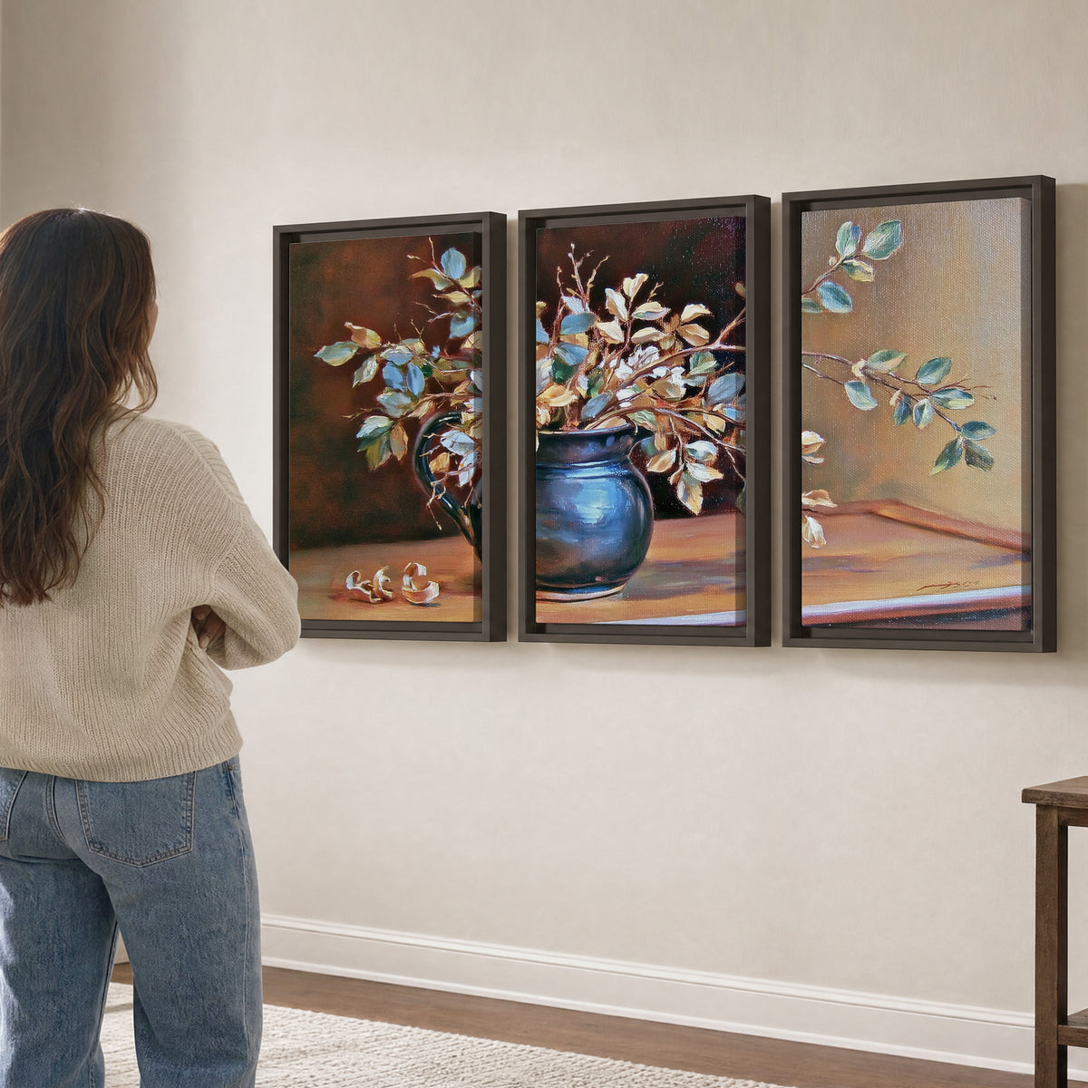 White and peach flowering branches arranged in a blue vase against a warm ochre background 3 piece framed canvas wall art three panel arrangement on a wall