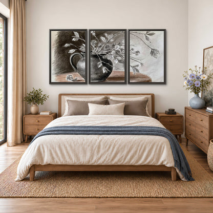 Fine leafy branches spilling from a dark rounded vase in a soft monochrome still life 3 piece framed canvas wall art styled in an interior
