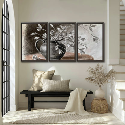 Fine leafy branches spilling from a dark rounded vase in a soft monochrome still life 3 piece framed canvas wall art displayed in a entryway
