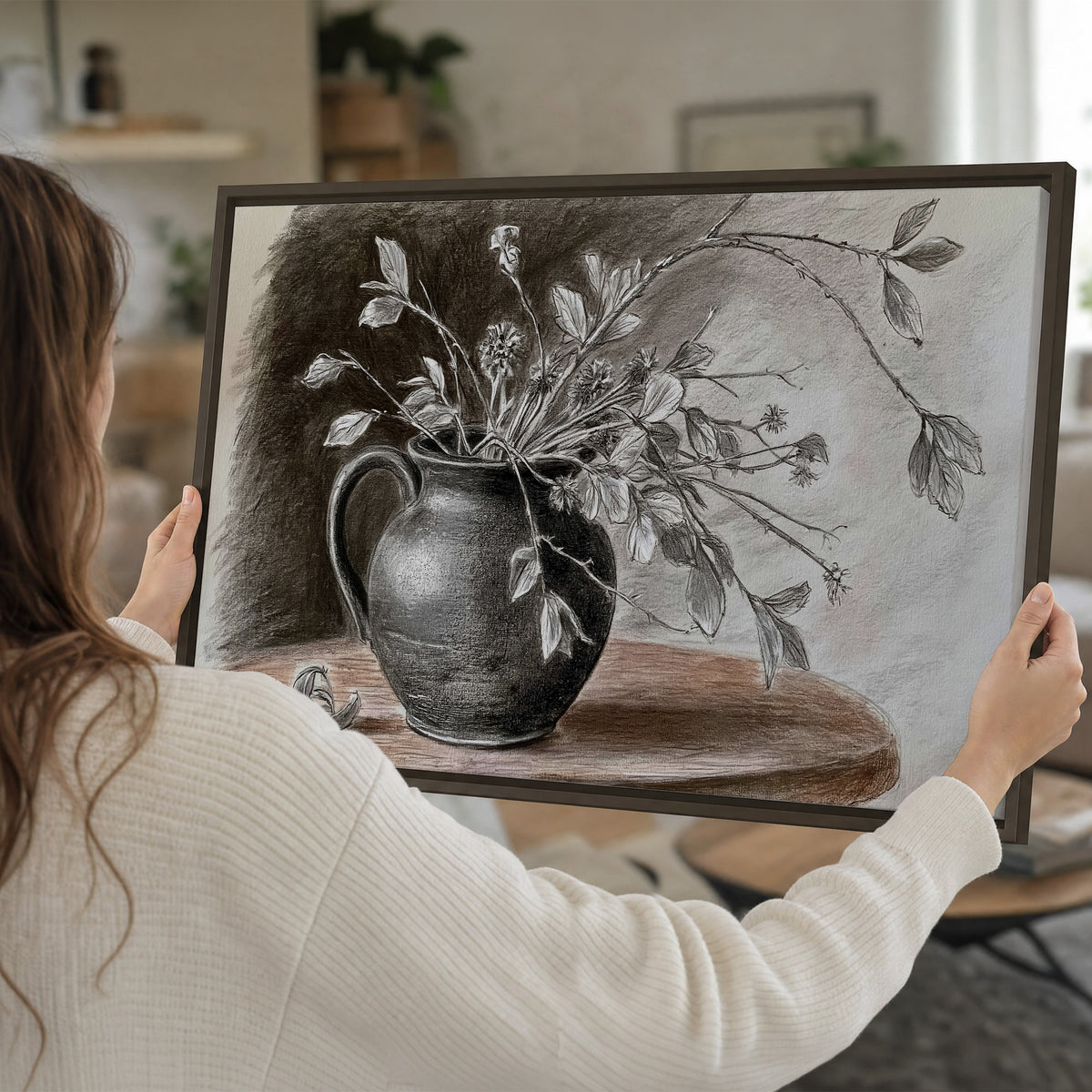Fine leafy branches spilling from a dark rounded vase in a soft monochrome still life single framed canvas wall art held in hands