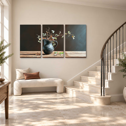 A delicate arrangement of pale blossoms in a blue vase on a sunlit wooden table 3 piece canvas wall art styled in an interior