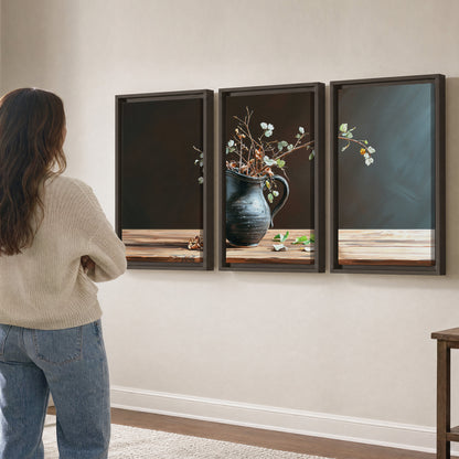 A delicate arrangement of pale blossoms in a blue vase on a sunlit wooden table 3 piece framed canvas wall art three panel arrangement on a wall