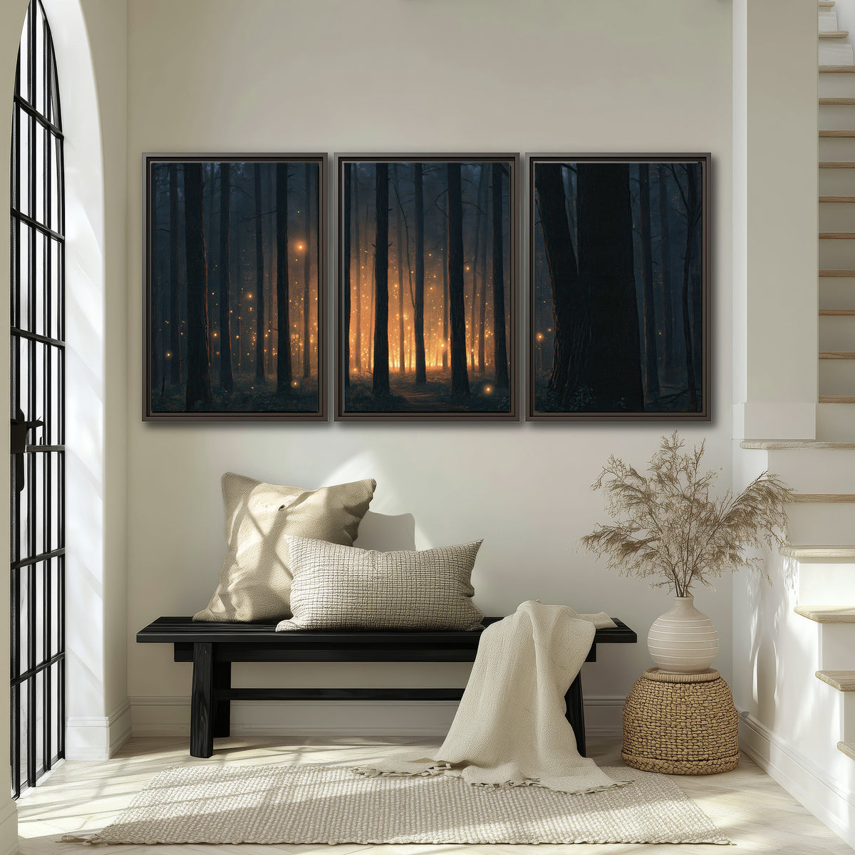 A warm amber glow shining between closely spaced dark forest trunks 3 piece framed canvas wall art displayed in a entryway