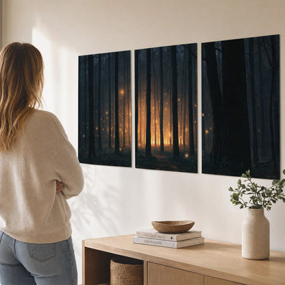 A warm amber glow shining between closely spaced dark forest trunks set of 3 poster prints three panel arrangement on a wall