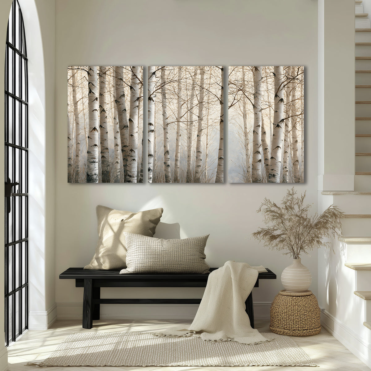 Pale birch trunks and delicate bare branches in a soft neutral woodland 3 piece canvas wall art displayed in a entryway