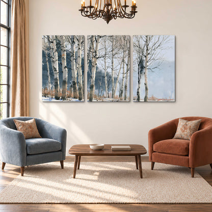 A line of bare birch trees against a cool blue-gray sky 3 piece canvas wall art styled in an interior