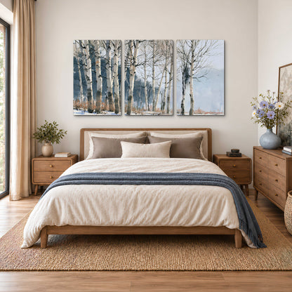 A line of bare birch trees against a cool blue-gray sky 3 piece canvas wall art styled in an interior