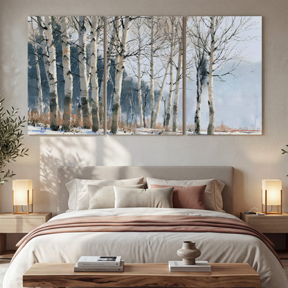 A line of bare birch trees against a cool blue-gray sky 3 piece canvas wall art displayed in a bedroom