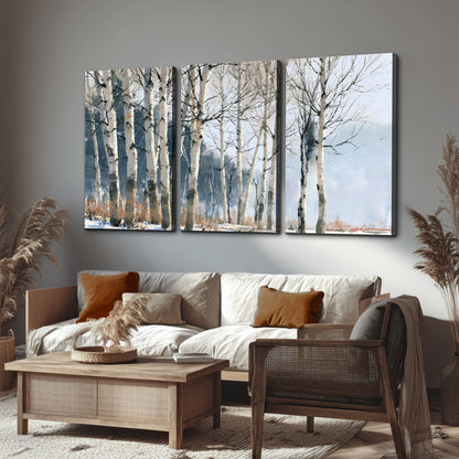 A line of bare birch trees against a cool blue-gray sky 3 piece canvas wall art displayed in a rustic living room