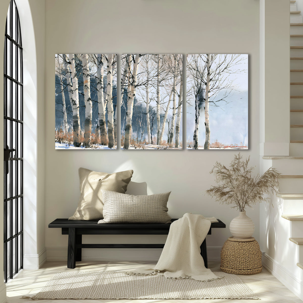 A line of bare birch trees against a cool blue-gray sky 3 piece canvas wall art displayed in a entryway