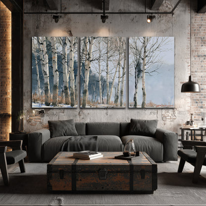A line of bare birch trees against a cool blue-gray sky 3 piece canvas wall art displayed in a industrial room
