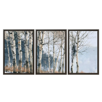 A line of bare birch trees against a cool blue-gray sky 3 piece framed canvas wall art viewed straight on