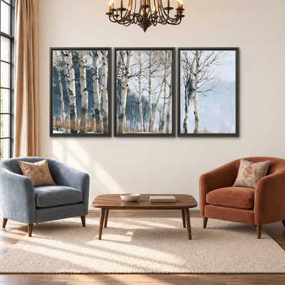 A line of bare birch trees against a cool blue-gray sky 3 piece framed canvas wall art styled in an interior
