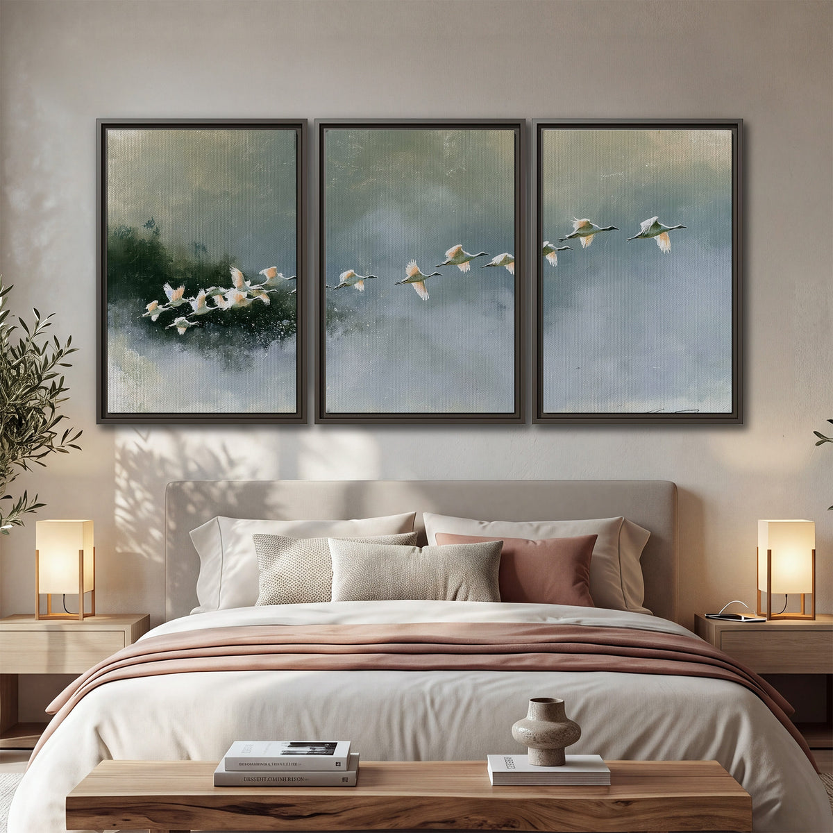 A flock of white birds flying low above a quiet blue-green lake 3 piece framed canvas wall art displayed in a bedroom