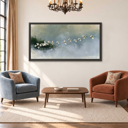 A flock of white birds flying low above a quiet blue-green lake single framed canvas wall art styled in an interior
