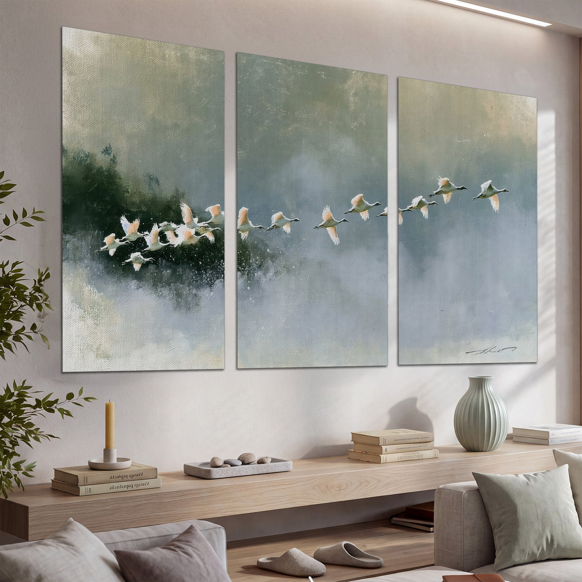 A flock of white birds flying low above a quiet blue-green lake set of 3 poster prints displayed in a console
