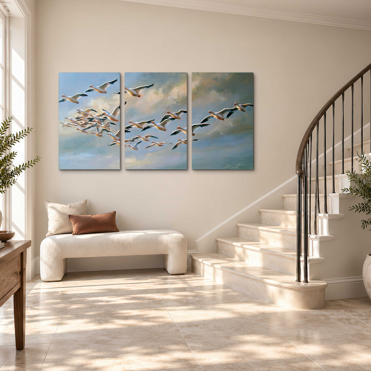 A flock of pale seabirds gliding beneath soft clouds across a blue sky 3 piece canvas wall art styled in an interior