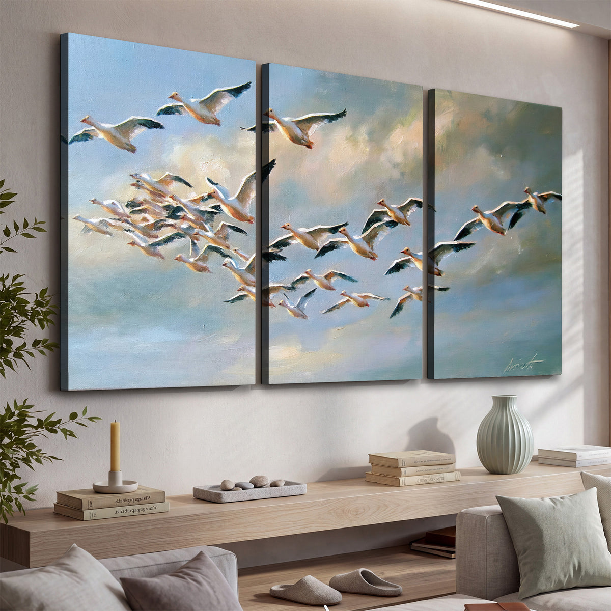 A flock of pale seabirds gliding beneath soft clouds across a blue sky 3 piece canvas wall art displayed in a console