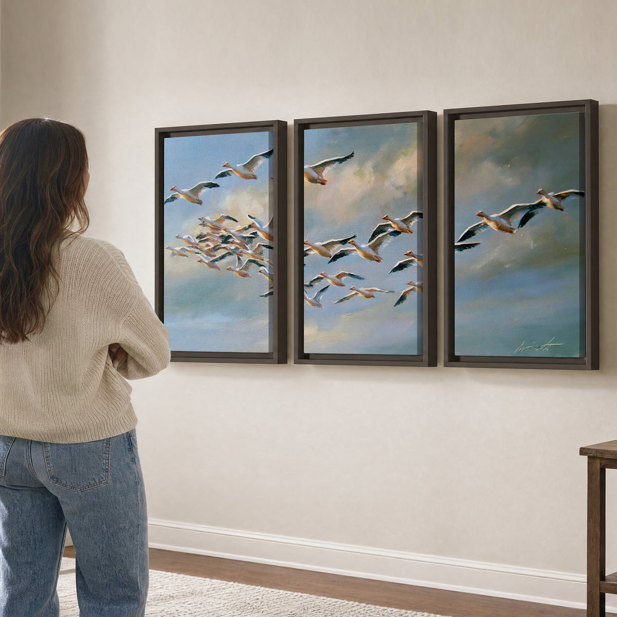 A flock of pale seabirds gliding beneath soft clouds across a blue sky 3 piece framed canvas wall art three panel arrangement on a wall