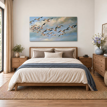 A flock of pale seabirds gliding beneath soft clouds across a blue sky single canvas wall art styled in an interior
