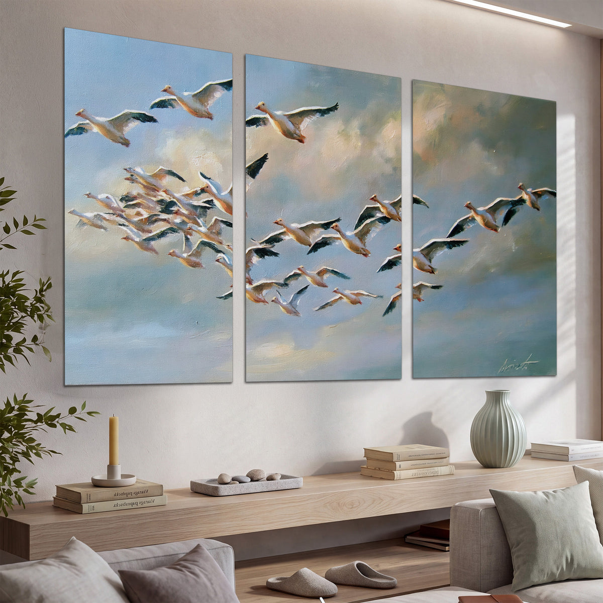 A flock of pale seabirds gliding beneath soft clouds across a blue sky set of 3 poster prints displayed in a console