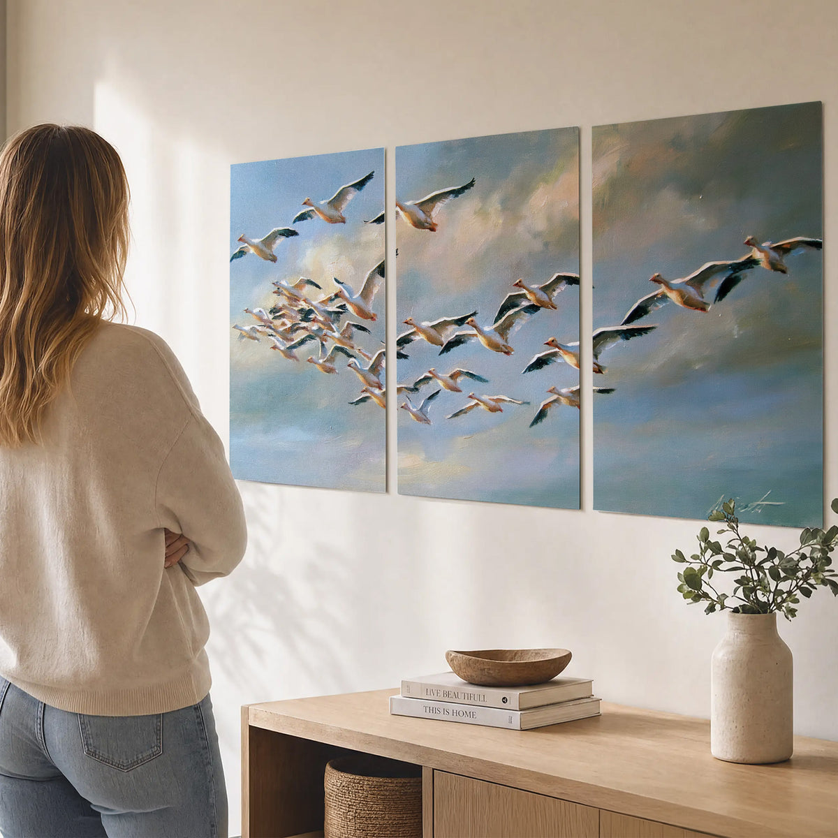 A flock of pale seabirds gliding beneath soft clouds across a blue sky set of 3 poster prints three panel arrangement on a wall