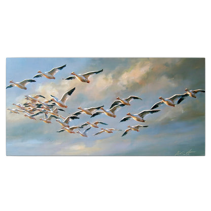 A flock of pale seabirds gliding beneath soft clouds across a blue sky single canvas wall art viewed straight on
