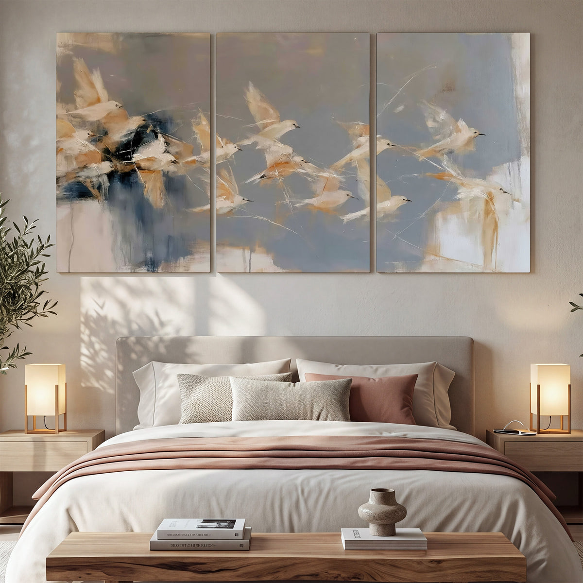 Pale bird-like forms sweeping across layered strokes of blue, ochre and cream 3 piece canvas wall art displayed in a bedroom