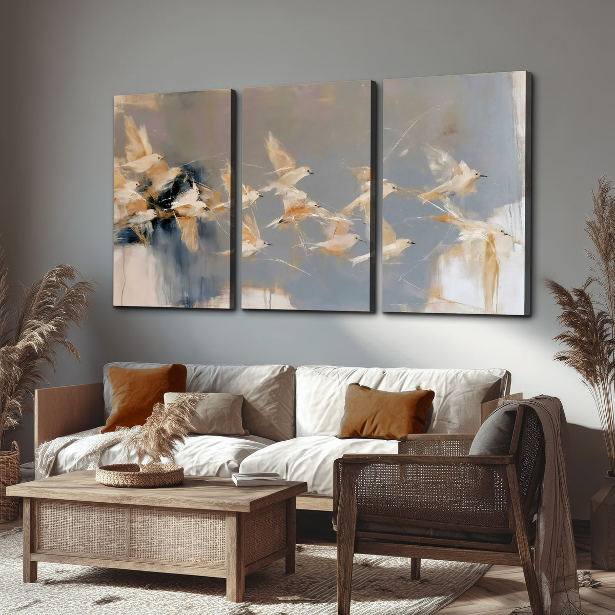 Pale bird-like forms sweeping across layered strokes of blue, ochre and cream 3 piece canvas wall art displayed in a rustic living room