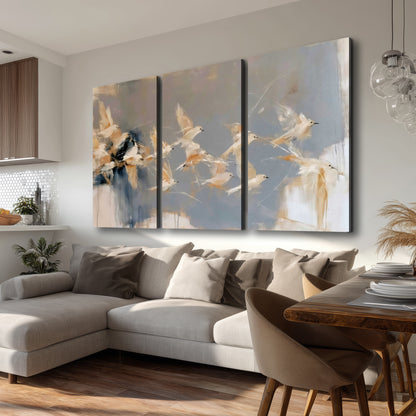 Pale bird-like forms sweeping across layered strokes of blue, ochre and cream 3 piece canvas wall art room and product view