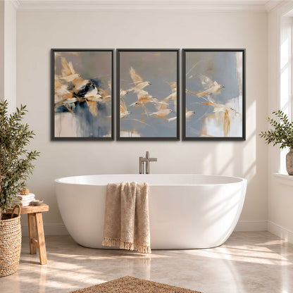 Pale bird-like forms sweeping across layered strokes of blue, ochre and cream 3 piece framed canvas wall art styled in an interior