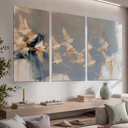 Pale bird-like forms sweeping across layered strokes of blue, ochre and cream set of 3 poster prints displayed in a console