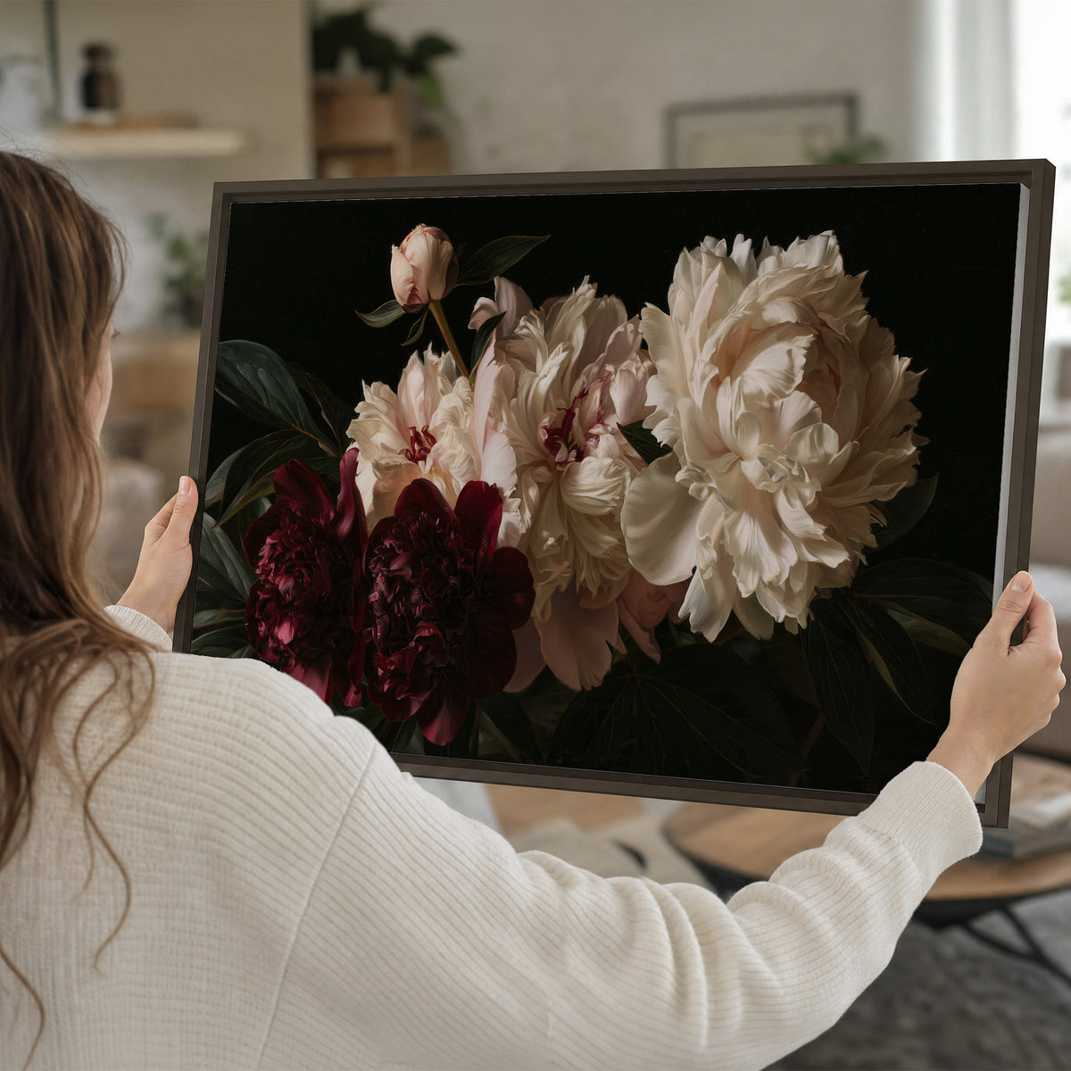 Full ivory and deep burgundy peonies against a dark green background single framed canvas wall art held in hands