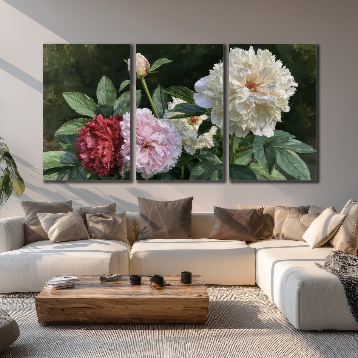 Cream, blush and red peonies surrounded by fresh green leaves 3 piece canvas wall art displayed in a living room