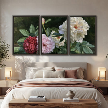Cream, blush and red peonies surrounded by fresh green leaves 3 piece framed canvas wall art displayed in a bedroom