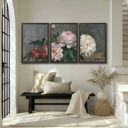 Cream and dusty pink peonies arranged against a muted gray-green background 3 piece framed canvas wall art displayed in a entryway