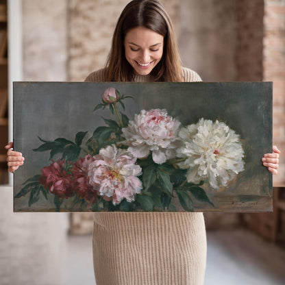 Cream and dusty pink peonies arranged against a muted gray-green background single canvas wall art held in hands