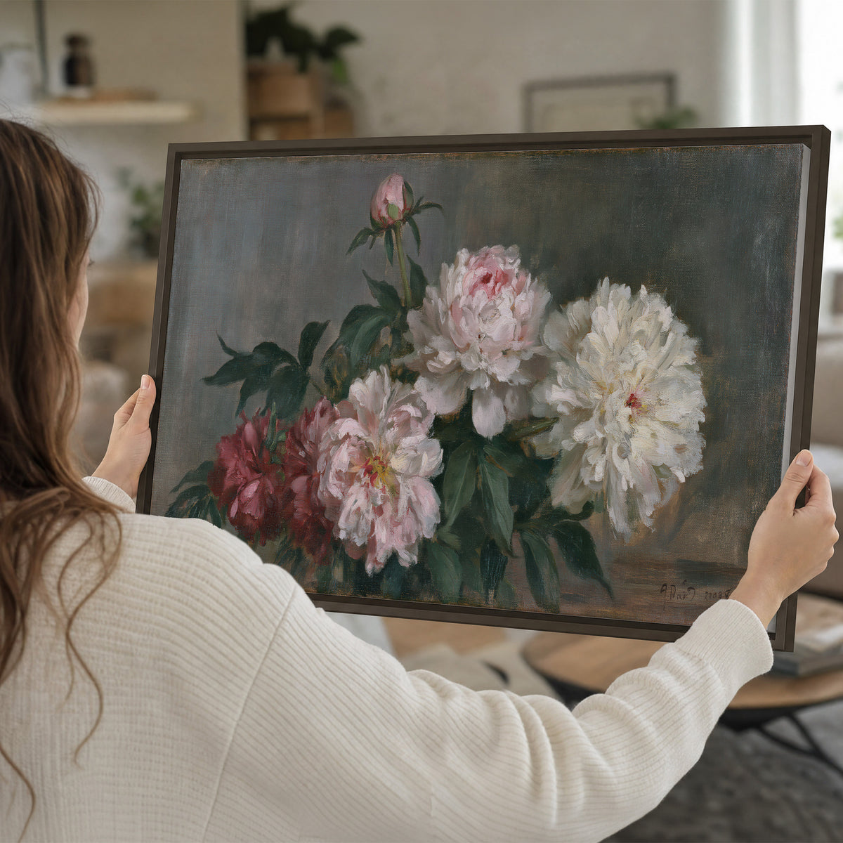 Cream and dusty pink peonies arranged against a muted gray-green background single framed canvas wall art held in hands