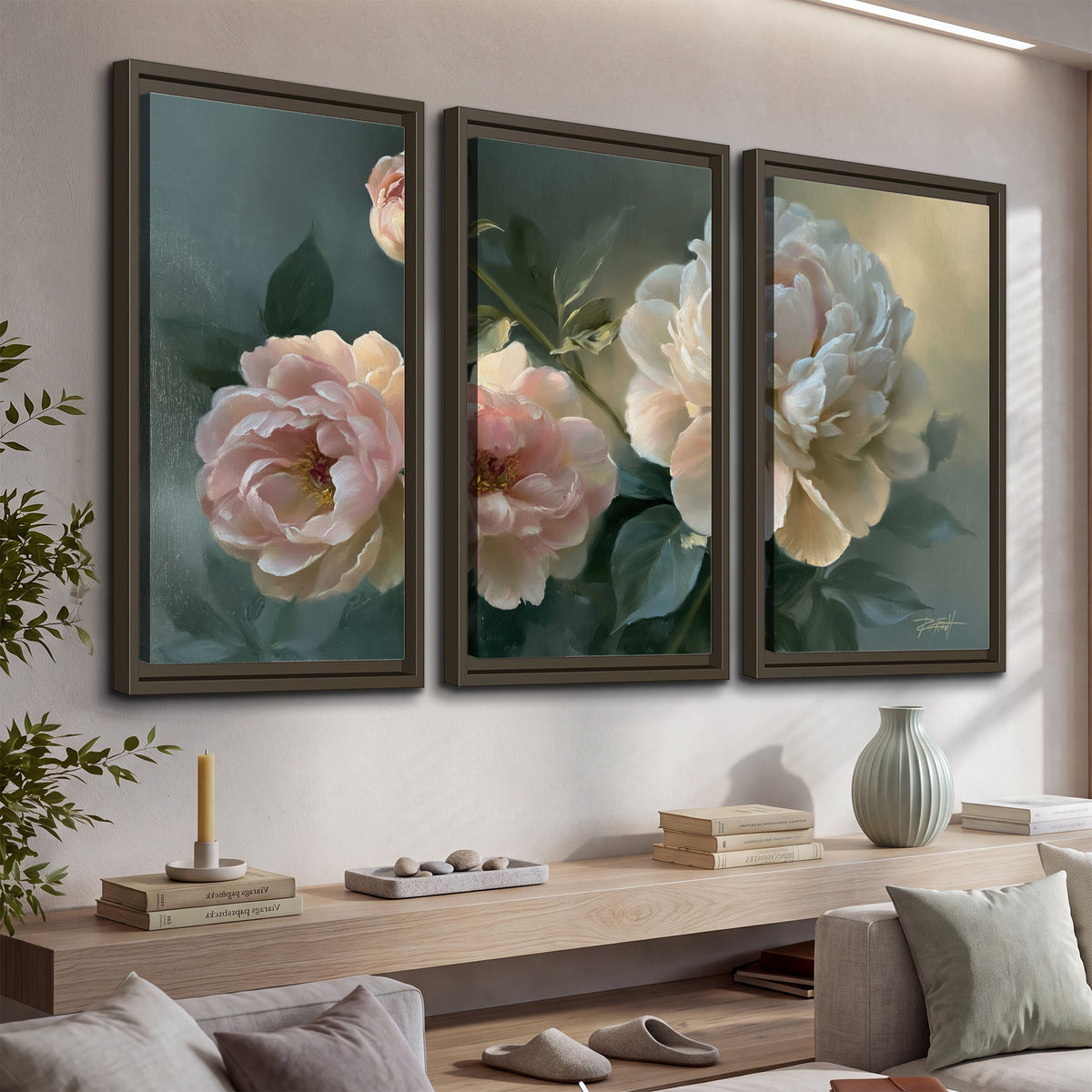 A large cream peony beside blush flowers and broad green leaves 3 piece framed canvas wall art displayed in a console