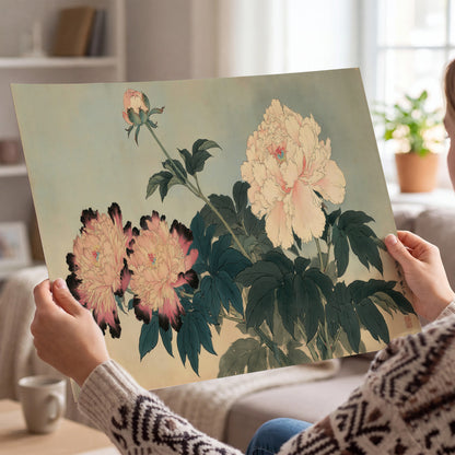 Pink and cream peonies with dark green leaves on a warm beige ground single poster print held in hands