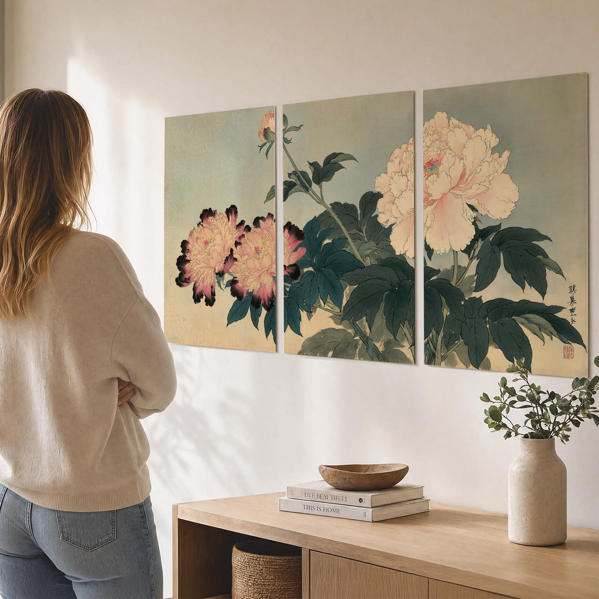 Pink and cream peonies with dark green leaves on a warm beige ground set of 3 poster prints three panel arrangement on a wall