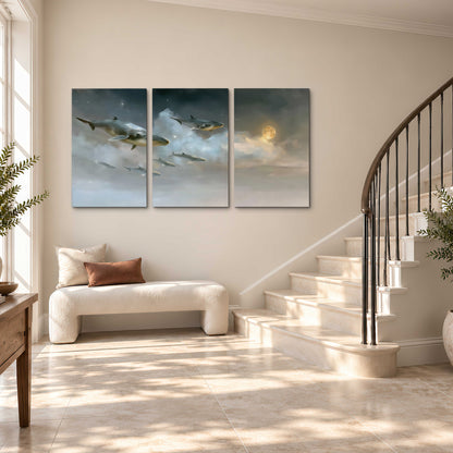 Whales drifting through pale dreamlike clouds toward a golden moon 3 piece canvas wall art styled in an interior