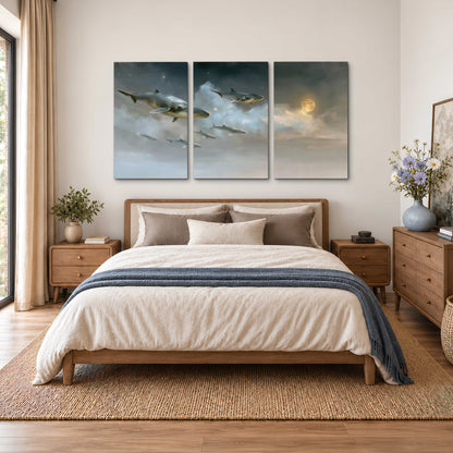 Whales drifting through pale dreamlike clouds toward a golden moon 3 piece canvas wall art styled in an interior