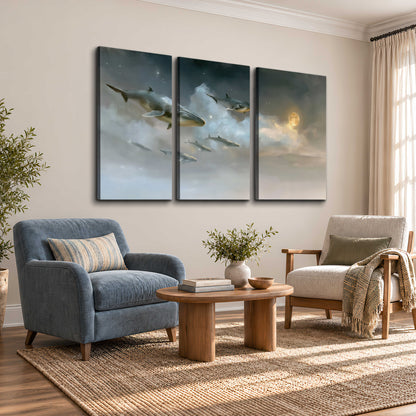 Whales drifting through pale dreamlike clouds toward a golden moon 3 piece canvas wall art styled in an interior