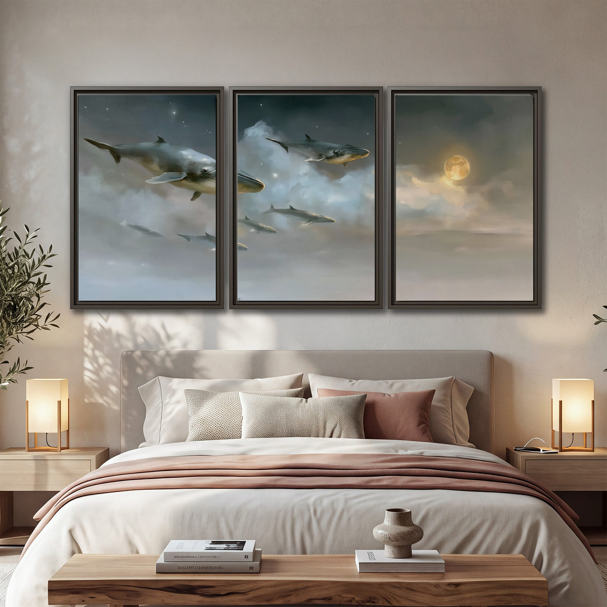 Whales drifting through pale dreamlike clouds toward a golden moon 3 piece framed canvas wall art displayed in a bedroom